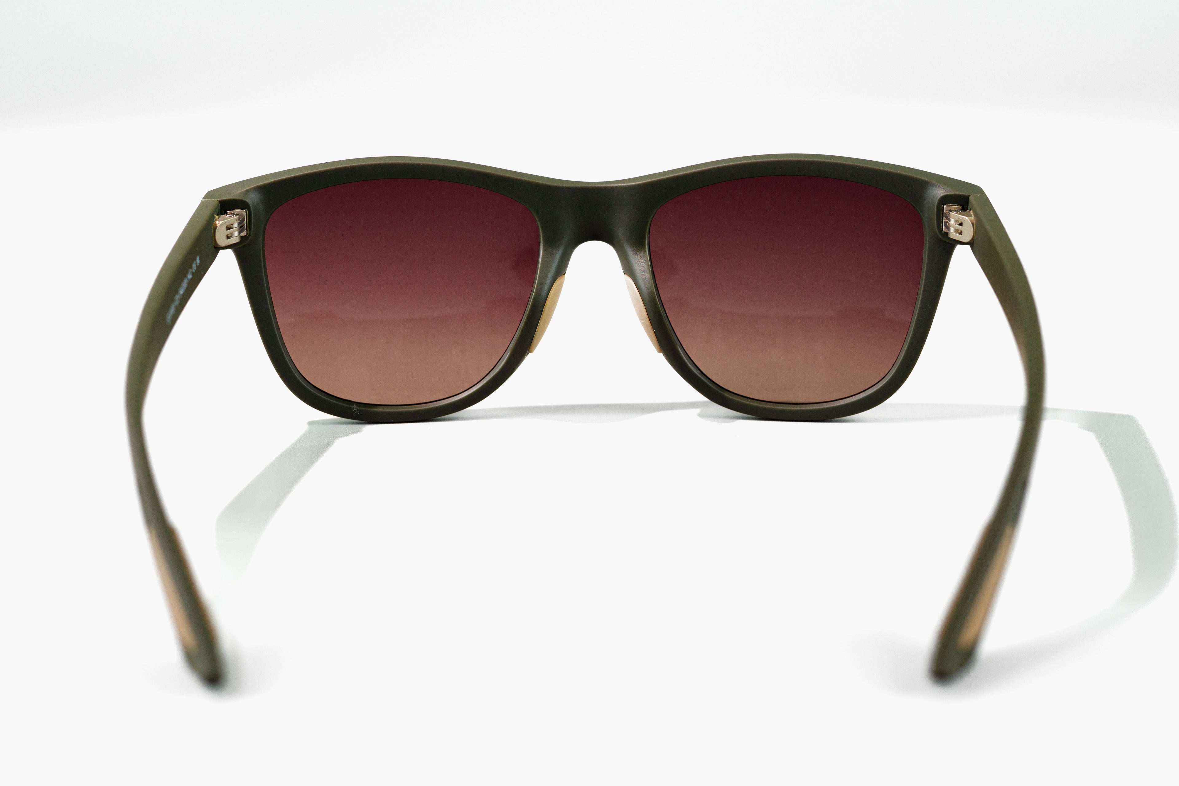 Sunglasses with a green frame and brown gradient lenses on a white background