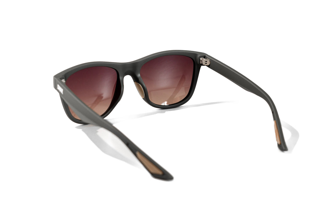 Sunglasses with dark frames and red-tinted lenses on a white background