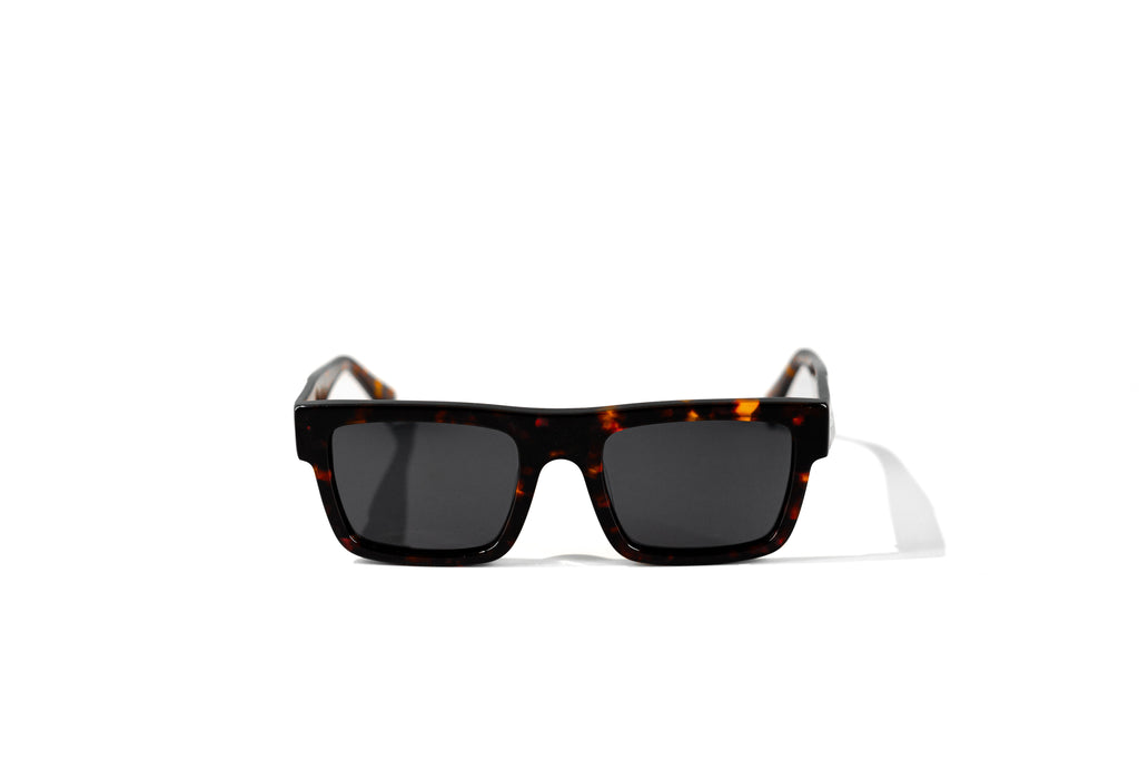 Sunglasses with tortoiseshell frame and dark lenses on a white background