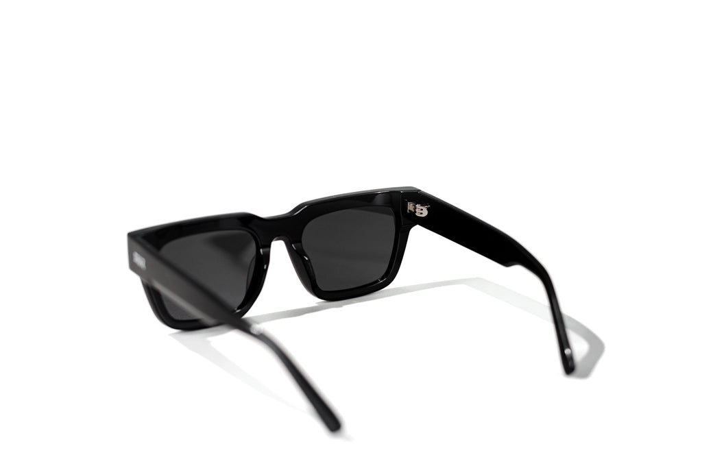 Black sunglasses with dark lenses on a white background