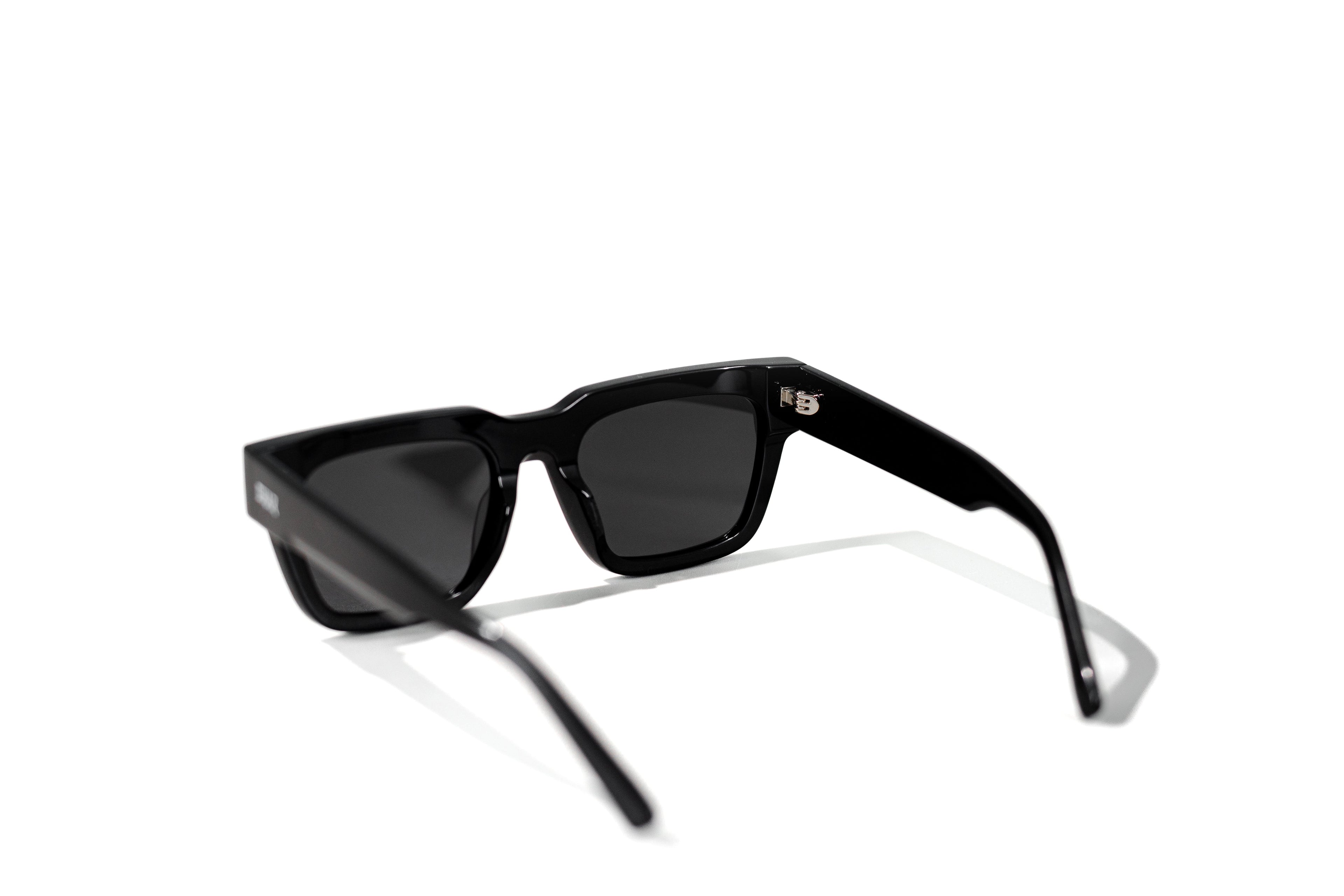 Black sunglasses with dark lenses on a white background