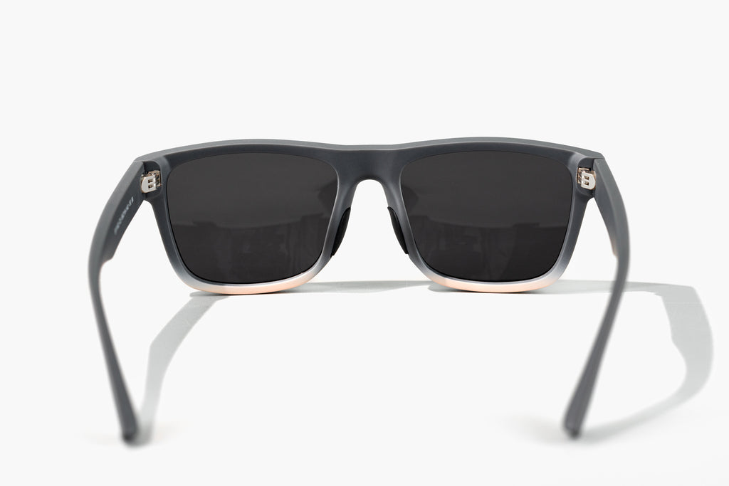 Sunglasses with dark lenses and gray frames on a white background