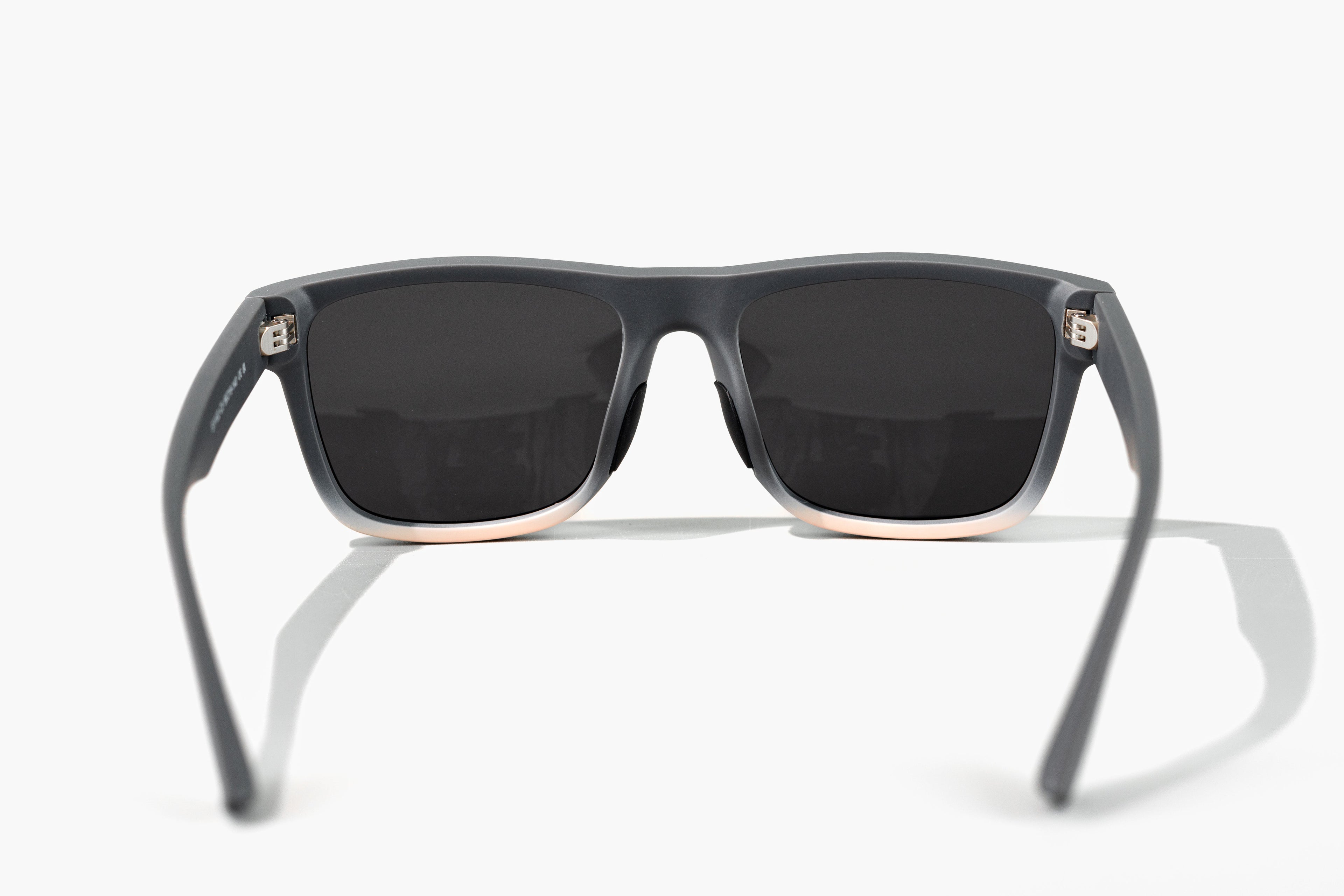 Sunglasses with dark lenses and gray frames on a white background